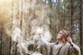 A man in a cassock spends a ritual in a dark forest