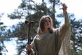 A man in a cassock spends a ritual in a dark forest