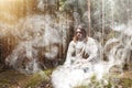 A man in a cassock spends a ritual in a dark forest