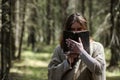 A man in a cassock spends a ritual in a dark forest