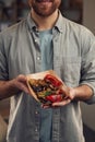 Man in casual clothes is holding food that are in the paper eco box. Potatoes, sausages, mushrooms, zucchini Royalty Free Stock Photo