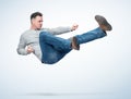 Man in casual clothes make karate fight jump, on light background