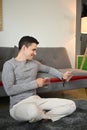 Man in casual clothes sitting in living room and using digital tablet. Royalty Free Stock Photo