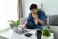 the man in casual clothes working with a laptop, computer, smart phone, calculator sitting on the sofa in the living room at home Royalty Free Stock Photo