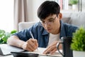 the man in casual clothes working with a laptop, computer, smart phone, calculator sitting on the sofa in the living room at home Royalty Free Stock Photo