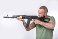 Man in casual clothing with sniper rifle aiming  on white Royalty Free Stock Photo