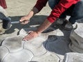 Man in casual wear is laying decorative pavement tiles with a black rubber mallet. Photo shows a part of male body, a pile of Royalty Free Stock Photo