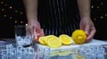man catch fresh lemon and slice lemon on cutting board near ice, glass Royalty Free Stock Photo