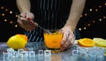 man catch glass, stir ice and orange near fresh slice lemon and orange Royalty Free Stock Photo