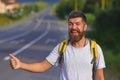 Man catches car on road, auto stop traveling. Auto stop travel. Guy is hitchhiking. A man are voting on the road. Man