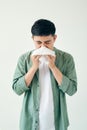 A asian man catches a cold, illness isolated over color wall