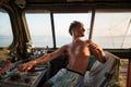 Man Caucasian seated in the driver& x27;s cab of a large locomotive looking back