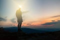 Man celebrating sunset looking at view in mountains