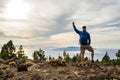 Man celebrating sunset looking at view in mountains