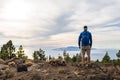 Man celebrating sunset looking at view in mountains