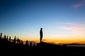 Man celebrating sunset looking at view in mountains