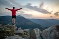 Man celebrating sunset looking at view in mountains