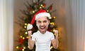 Man celebrating victory over christmas tree Royalty Free Stock Photo