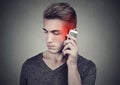 Man on the cellphone with headache. Upset unhappy guy talking on a phone Royalty Free Stock Photo