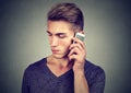 Man on the cellphone with headache. Upset unhappy guy talking on phone Royalty Free Stock Photo