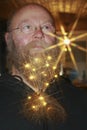 Man with chain of lights, with sparkling asterisks in his beard Royalty Free Stock Photo