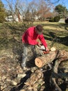 Man with a chain saw cutting up a fallen tree limb for firewood Royalty Free Stock Photo