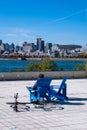 Man in a chair looking at Montreal Skyline from Parc Jean Drapeau, in the Autumn season Royalty Free Stock Photo