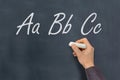 Man with chalk writing ABC letters on blackboard Royalty Free Stock Photo