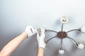 A man changes a light bulb in a chandelier at home. Maintenance of electrical appliances Royalty Free Stock Photo