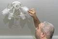 Man changes a light bulb in a lighting device