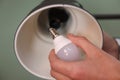 Man changing light bulb in lamp on greyish green background, closeup Royalty Free Stock Photo