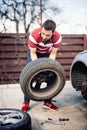 Man chaning wheel on the side of the road, flat tire details