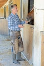 Man in chaps with horse Royalty Free Stock Photo