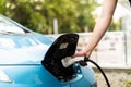 Man charging electric car. Man holding in hand power cable supply ready to plugged in into charging port Royalty Free Stock Photo