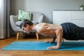 Man in chaturanga pose doing vinyasa flow at home Royalty Free Stock Photo