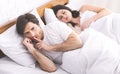 Man cheater talking privately on cellphone in family bed Royalty Free Stock Photo