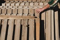 Man in check shirt choosing wooden euro pallets with his hand