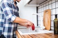 Man in checkered shirt washing dishes on the kitchen