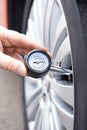 Close-Up Of Man Checking Car Tyre Pressure With Gauge Royalty Free Stock Photo