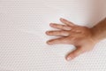 Man checking firmness of mattress, closeup