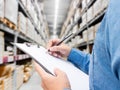 Man checking  list on clipboard in a warehouse Royalty Free Stock Photo