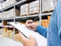 Man checking  list on clipboard in a warehouse Royalty Free Stock Photo