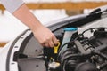 Man checking oil level in his car using dipstick