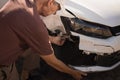 Man checking out the damage to the front end of his car Royalty Free Stock Photo