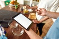 Make a Change. Man checking recipe using tablet pc while woman making smoothie. Vegetarians cooking in the kitchen