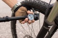 Man checking tire pressure of e bike, inflating air with hand pump Royalty Free Stock Photo