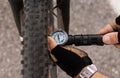 Man checking tire pressure of e bike, inflating air with hand pump Royalty Free Stock Photo