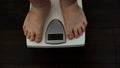 Man checking weight loss on scales, unhealthy nutrition, genetic predisposition