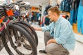 Man checks bicycle tyre, shopping in sports shop