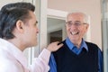 Man Checking On Elderly Male Neighbor